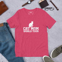 Cat mom world tour graphic featuring a cat, printed on a heather raspberry t-shirt, front view