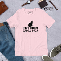 Cat mom world tour graphic featuring a cat, printed on a pink t-shirt, front view