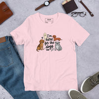 I'm here for the dogs graphic featuring dogs, printed on a pink t-shirt, front view